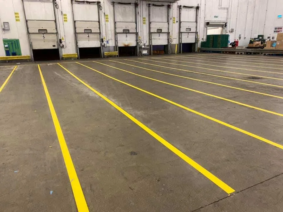Yellow warehouse floor lanes in front of numbered loading-bay doors.